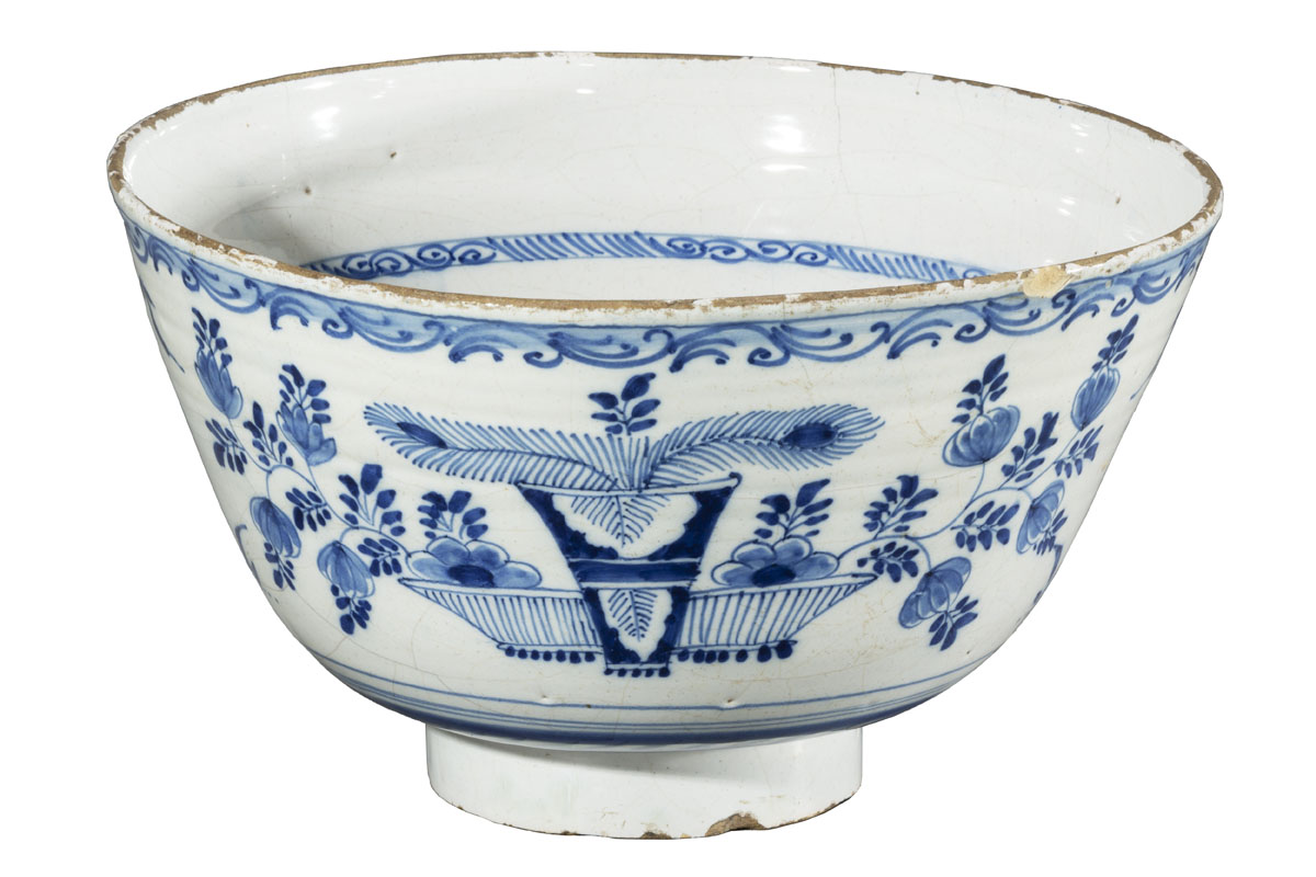 Punch Bowl, 1700-1730 White bowl with narrow base and body sloping outward to a wide mouth, with blue decorations of flowers, plants, and bowls of fruit