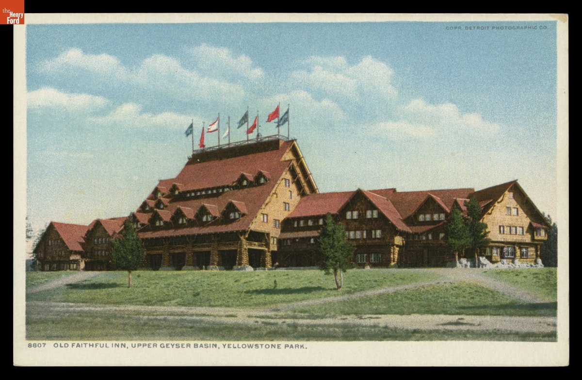 Old Faithful Inn, Upper Geyser Basin, Yellowstone Park, 1904-1905 Postcard of sprawling rustic building with steeply peaked roof topped with flags at center; also contains text
