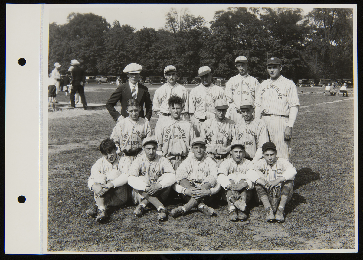 Henry Ford Trade School Baseball Team and Manager, August 1927 A group of boys and men in baseball uniforms pose for a photo in front of a baseball diamond