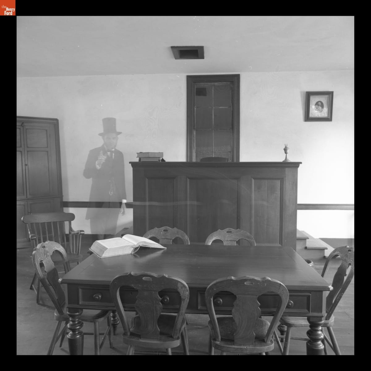 Transparent figure of Abraham Lincoln standing in room with table and dais