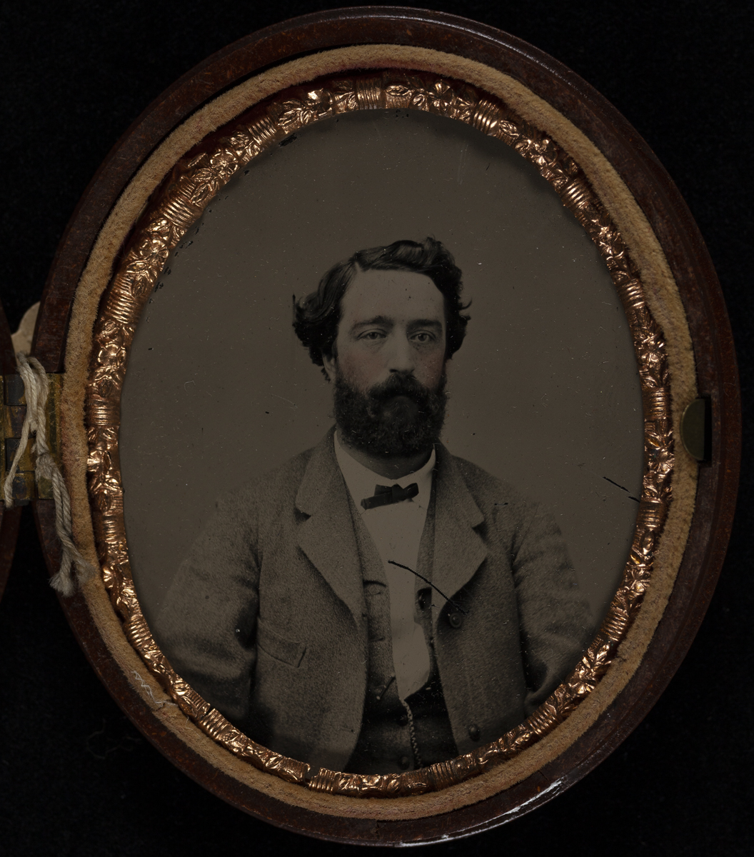 Torso and head of a man with a beard wearing a suit, in an oval frame