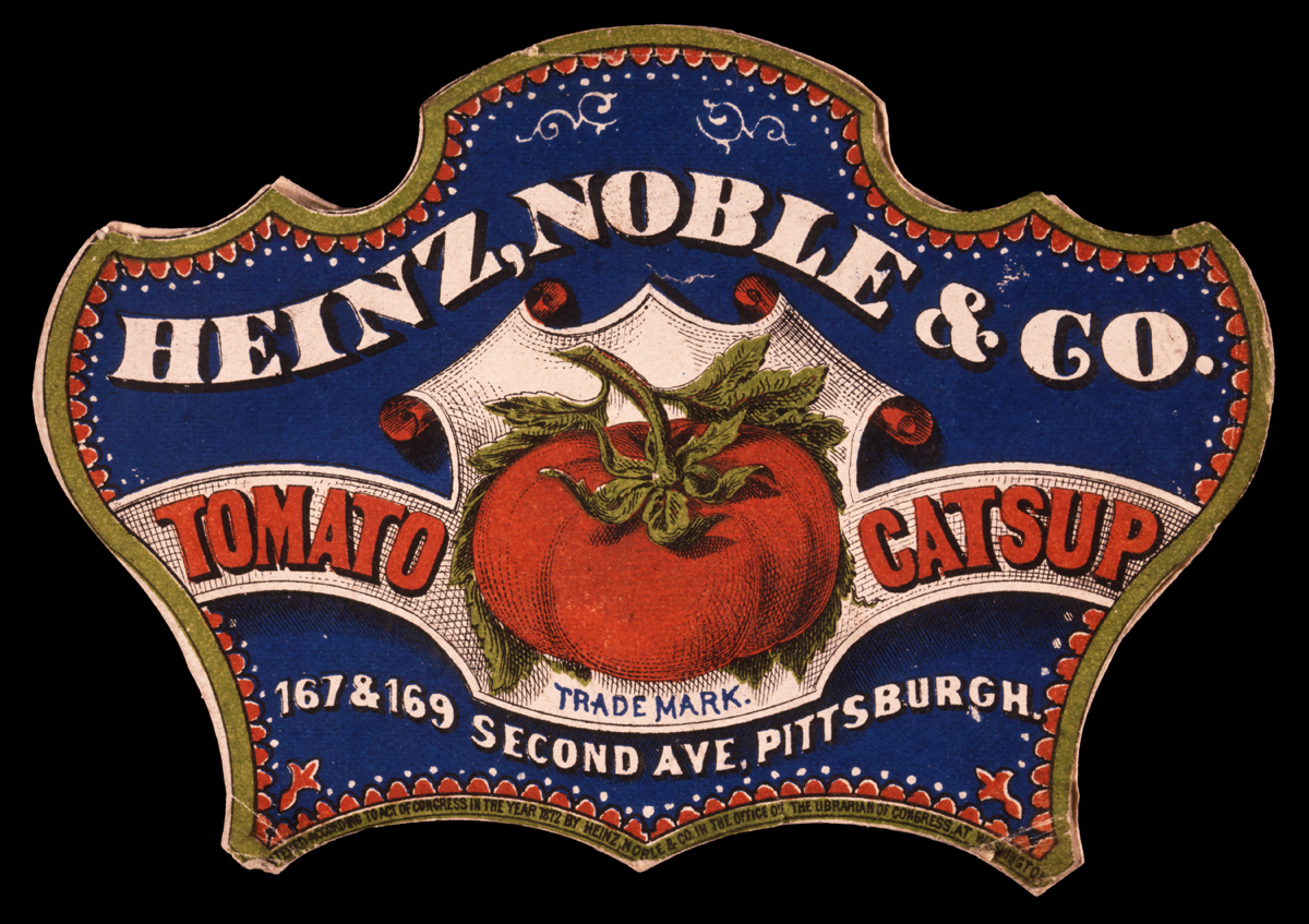 Fancy-shaped blue, gold, red, and white label with a picture of a tomato and text