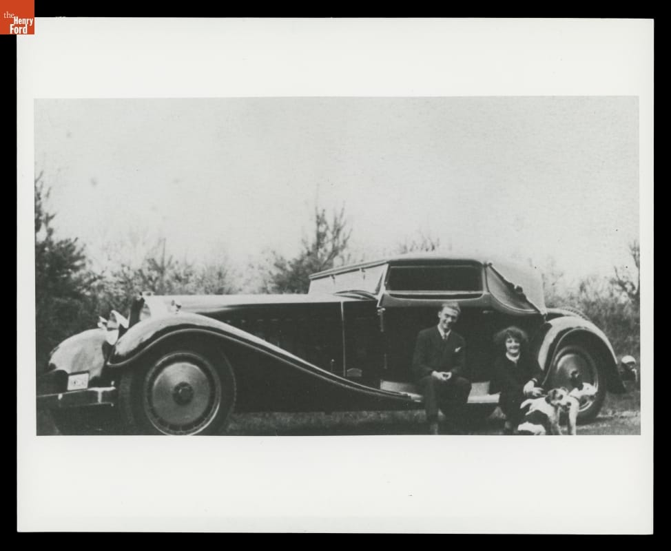 1931 Bugatti Royale Photographed in 1932 by the Owner, Dr. Joseph Fuchs Black-and-white photo of a long car with swooping style lines; two people and two dogs sitting outside car