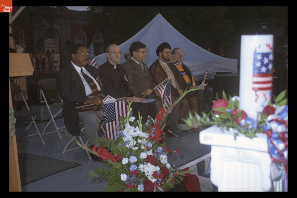 Photographs from the “Peace and Unity Candlelight Vigil” at The Henry Ford, September 19, 2001 GIF cycling through images of large crowd of people, many with American flags or candles, and speakers on a stage