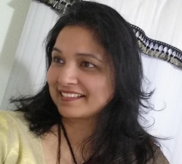 Krishma Patel, Carteret, New Jersey Medium-skinned woman with dark hair in front of white curtain with dark trim