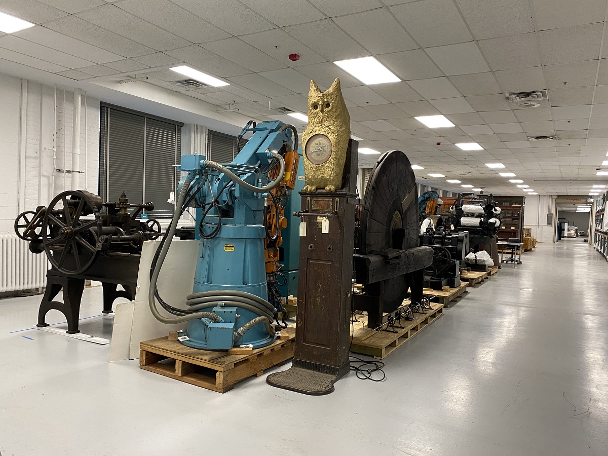 Large artifacts in MSB A variety of large objects sit on the floor or on pallets in a row in a large room