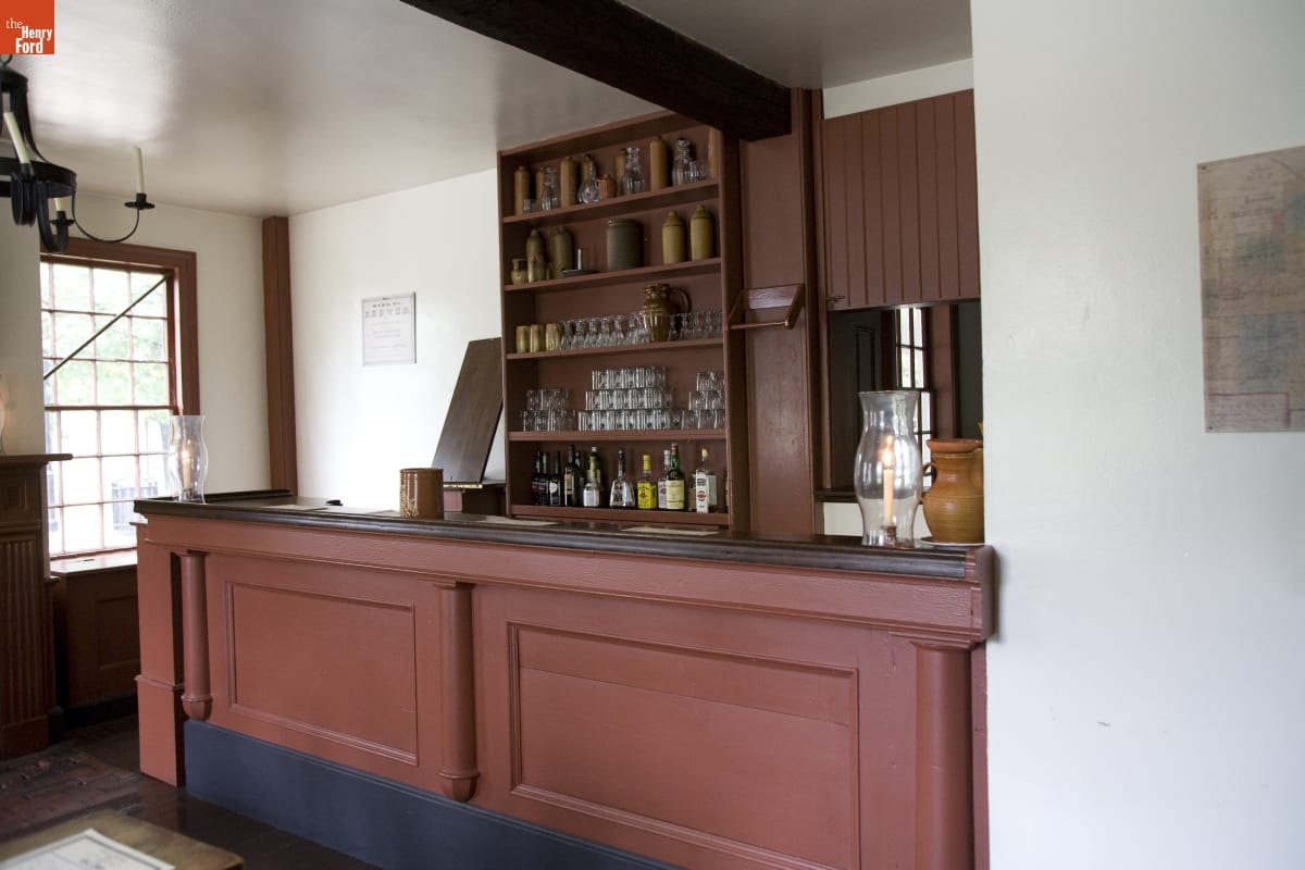 Eagle Tavern in Greenfield Village, October 2007 Room with a brown wooden bar, behind which are shelves containing liquor bottles, glasses, crocks, and decanters
