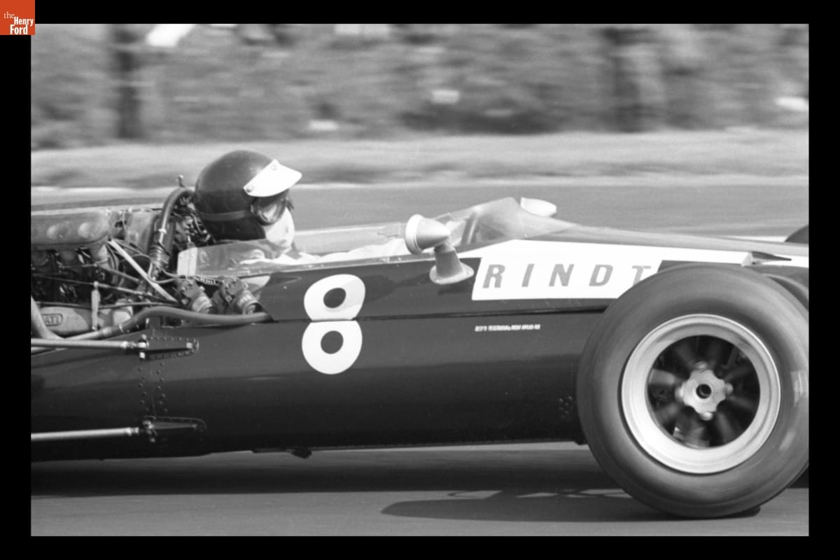 Cooper T81 Driven by Jochen Rindt in the V Gran Premio de Mexico (5th Grand Prix of Mexico), October 1966 Partial side view of racecar with text "8" and "RINDT" on side; person inside in helmet, goggles, and mouth covering