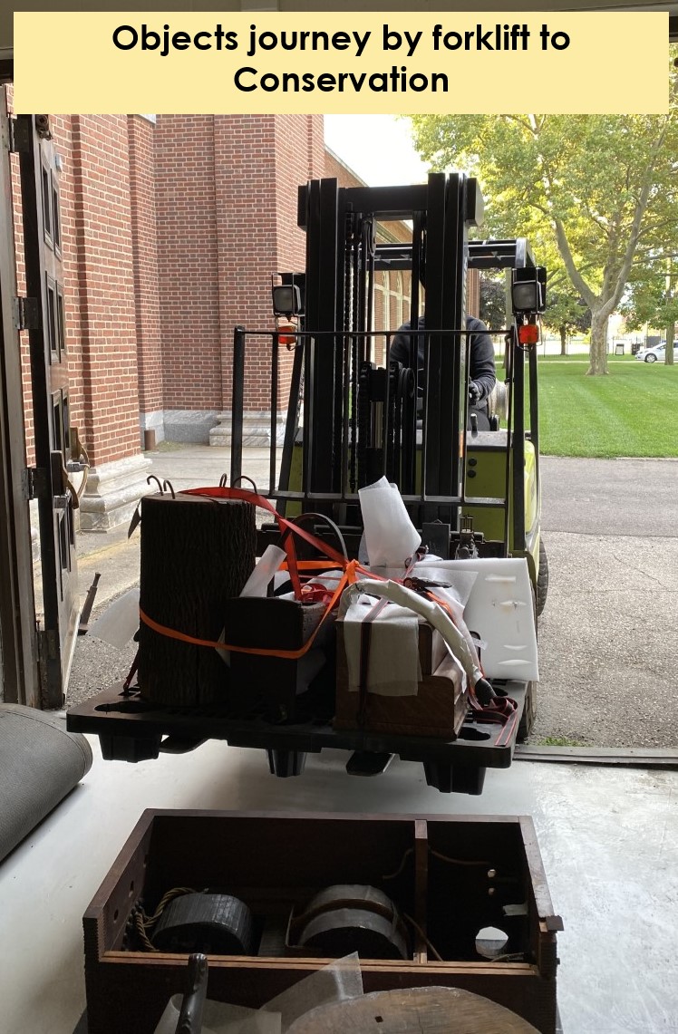 Artifacts move to conservation via forklift Front view of forklift loaded with bundles at large door