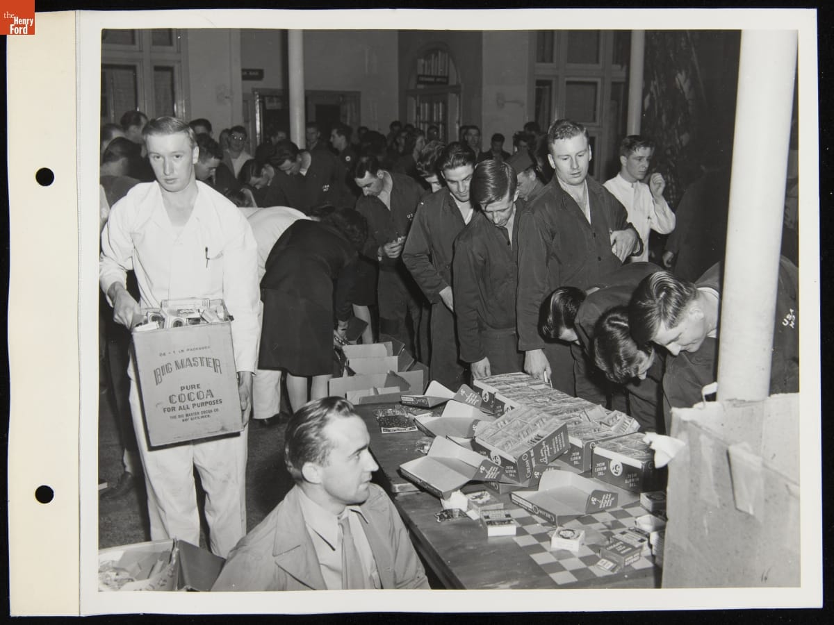 Candy Giveaway for Soldiers at Percy Jones Hospital, Battle Creek, Michigan, April 1944 Room filled with people, some carrying boxes, and tables with boxes on them