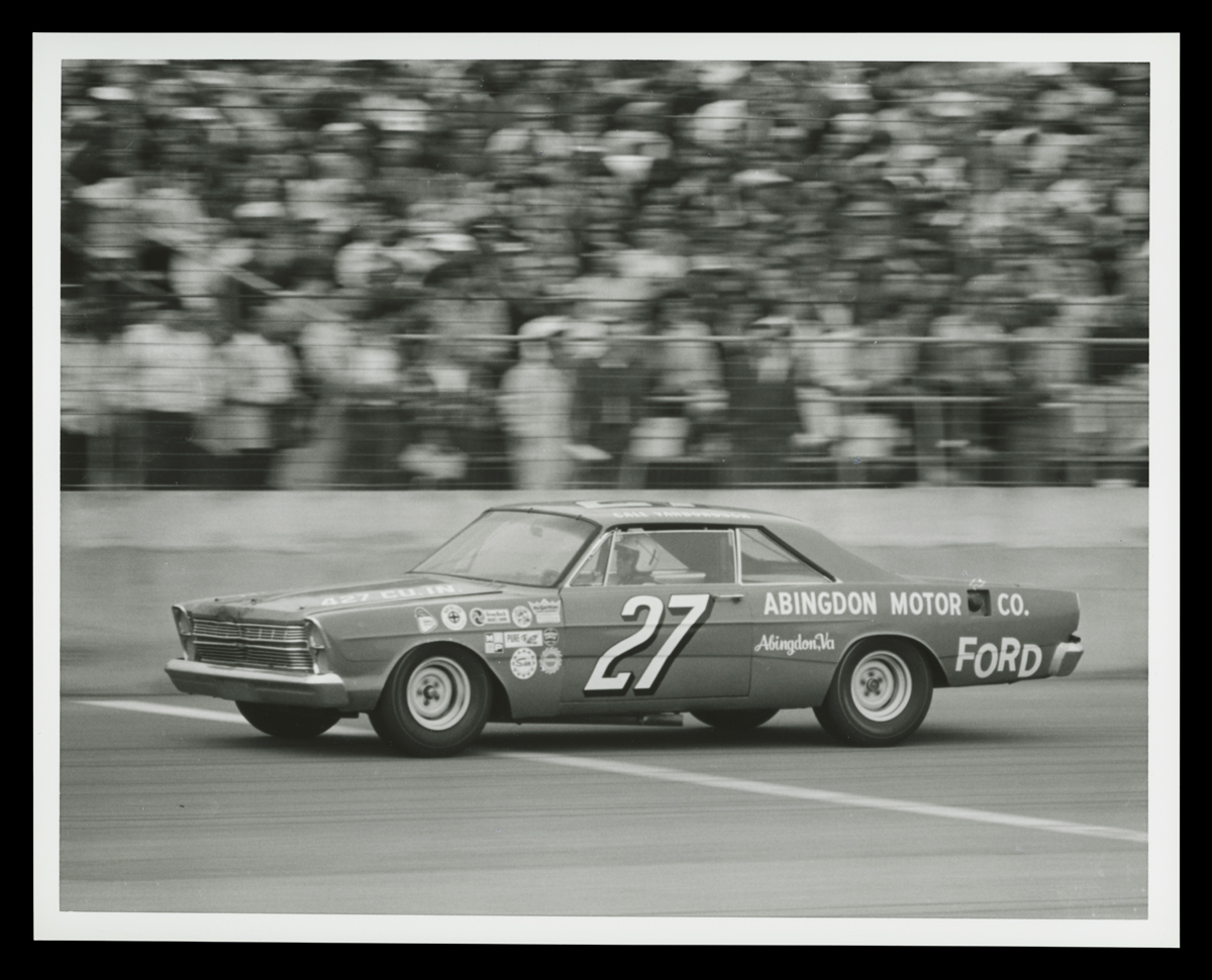 1966 Ford Galaxie Driven by Cale Yarborough in the Daytona 500, February 1966 Car, with large number 27 on door, in front of blurred stands full of people