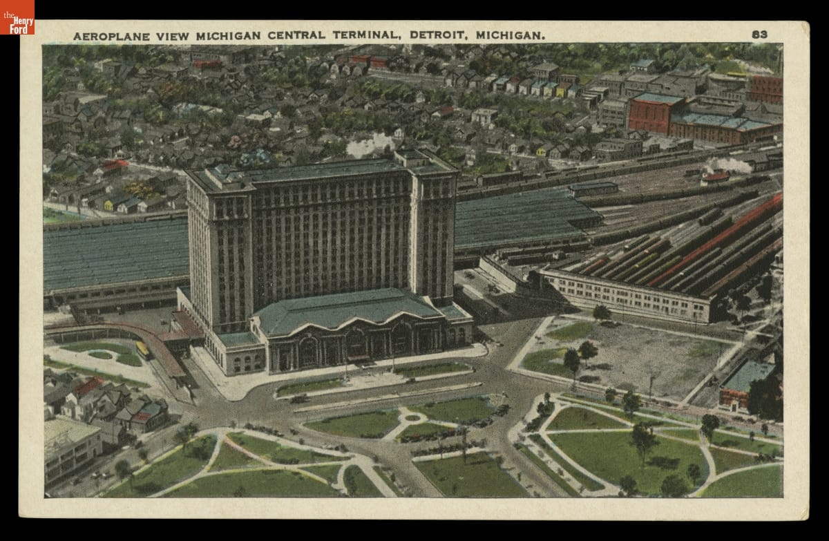 Aeroplane View Michigan Central Terminal, Detroit, Michigan, circa 1915 Aerial view of large building with railroad lines and trains behind and to one side of it; lawn and driveways in front and other buildings behind