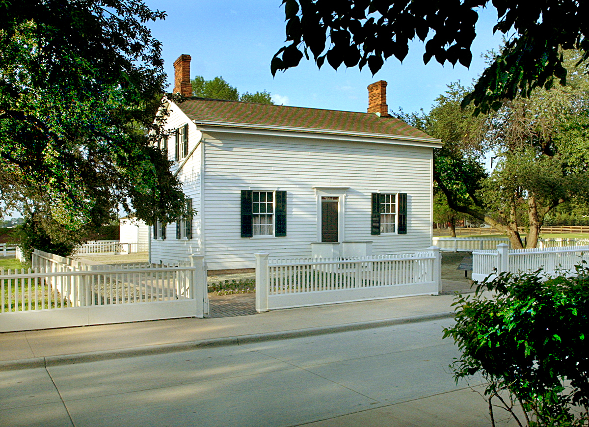 White wooden building with white picket fence in front