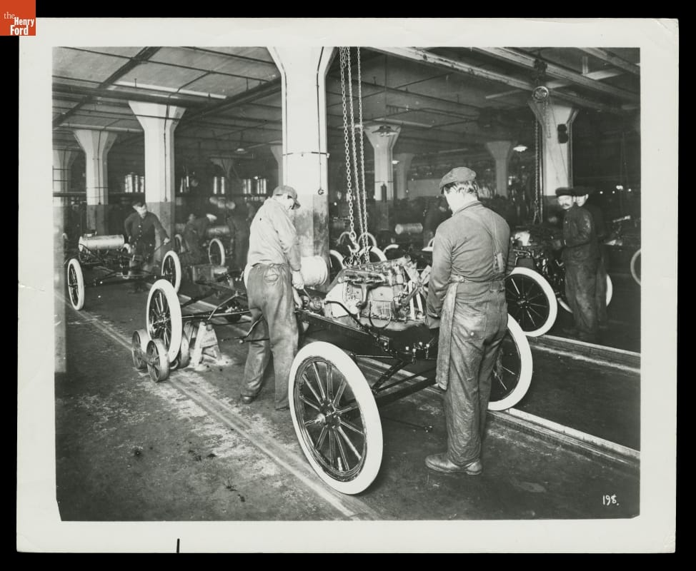 Workers Installing Engines on Ford Model T Assembly Line at Highland Park Plant, 1913 People work on car bodies in factory