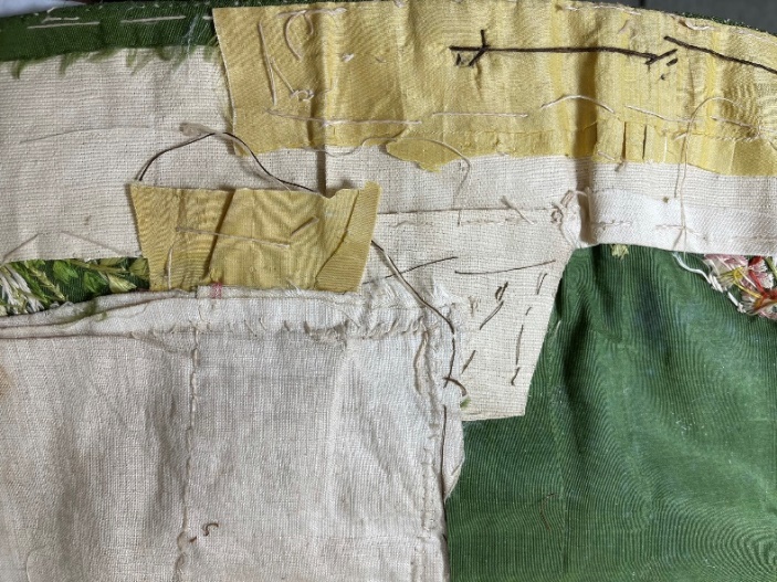 A quilt of patches, buckram, and pocket inside the jacket Numerous patches in various fabrics, layered messily upon each other