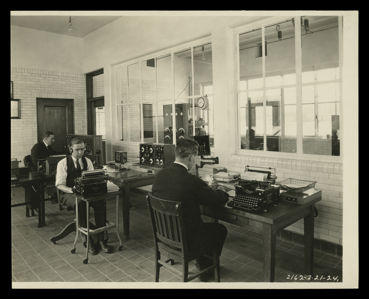 Ford Motor Company Radio Station WWI, Dearborn, Michigan, February 1924 Men sit at desks with typewriters and equipment