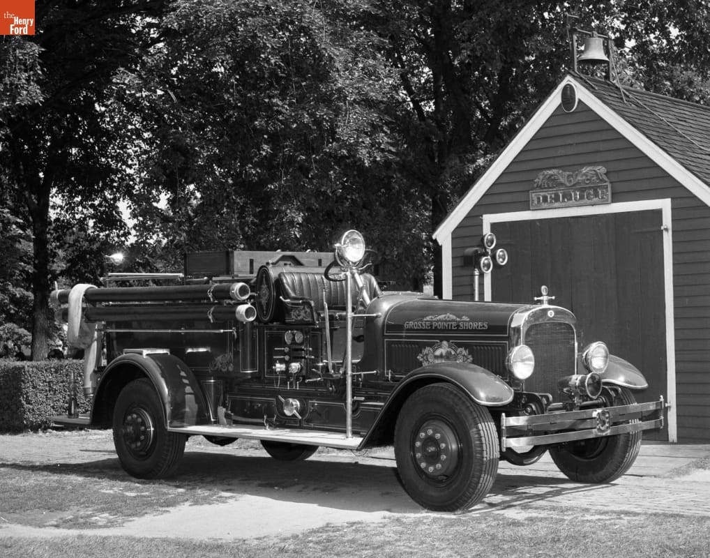 1923 Seagrave Pumper Fire Engine Black-and-white photo of fire engine parked in front of wooden shed or garage and trees