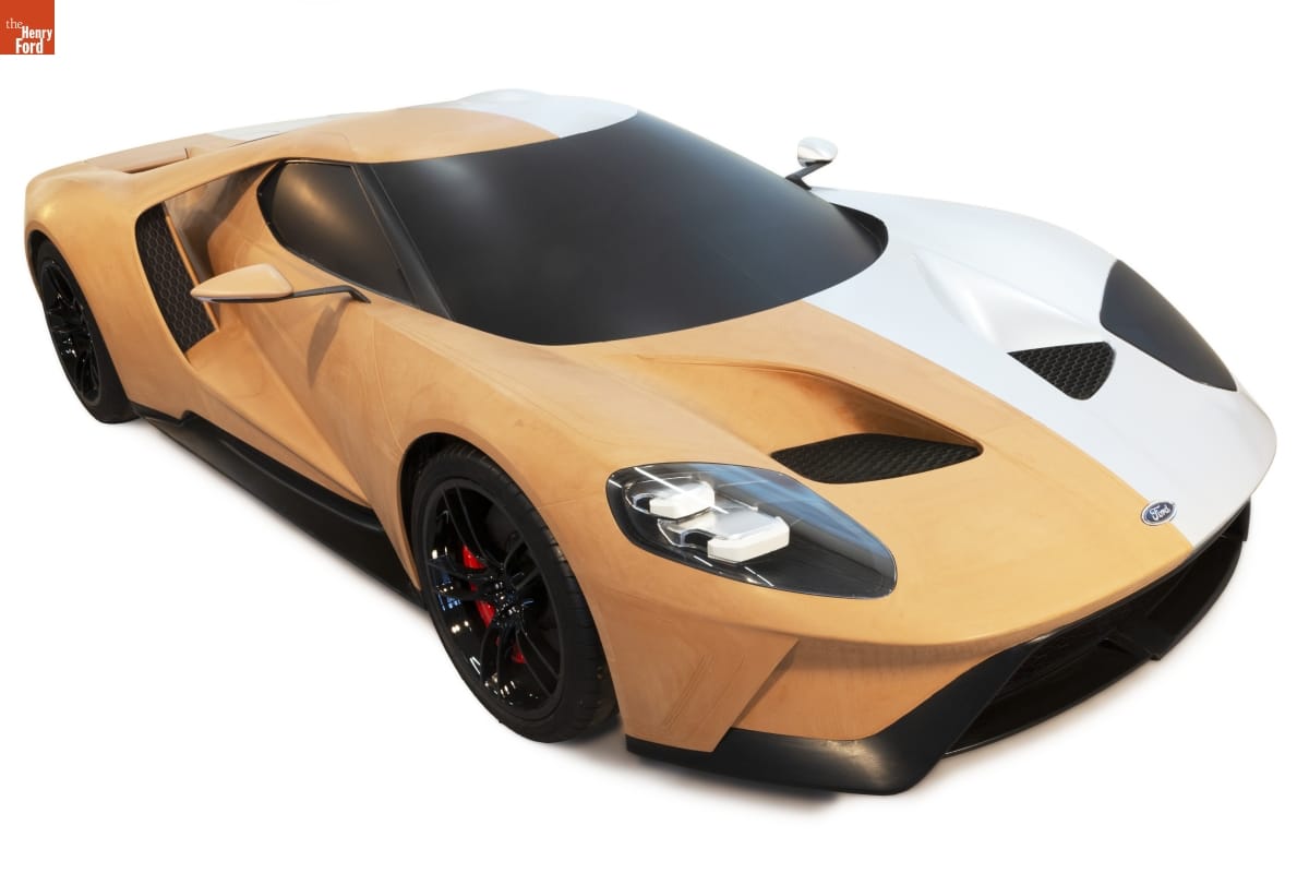 2016 Ford GT Full-Size Clay Model, 2014 Car, half of which is orange clay-colored and half of which is white, with black windshield, wheels, and trim