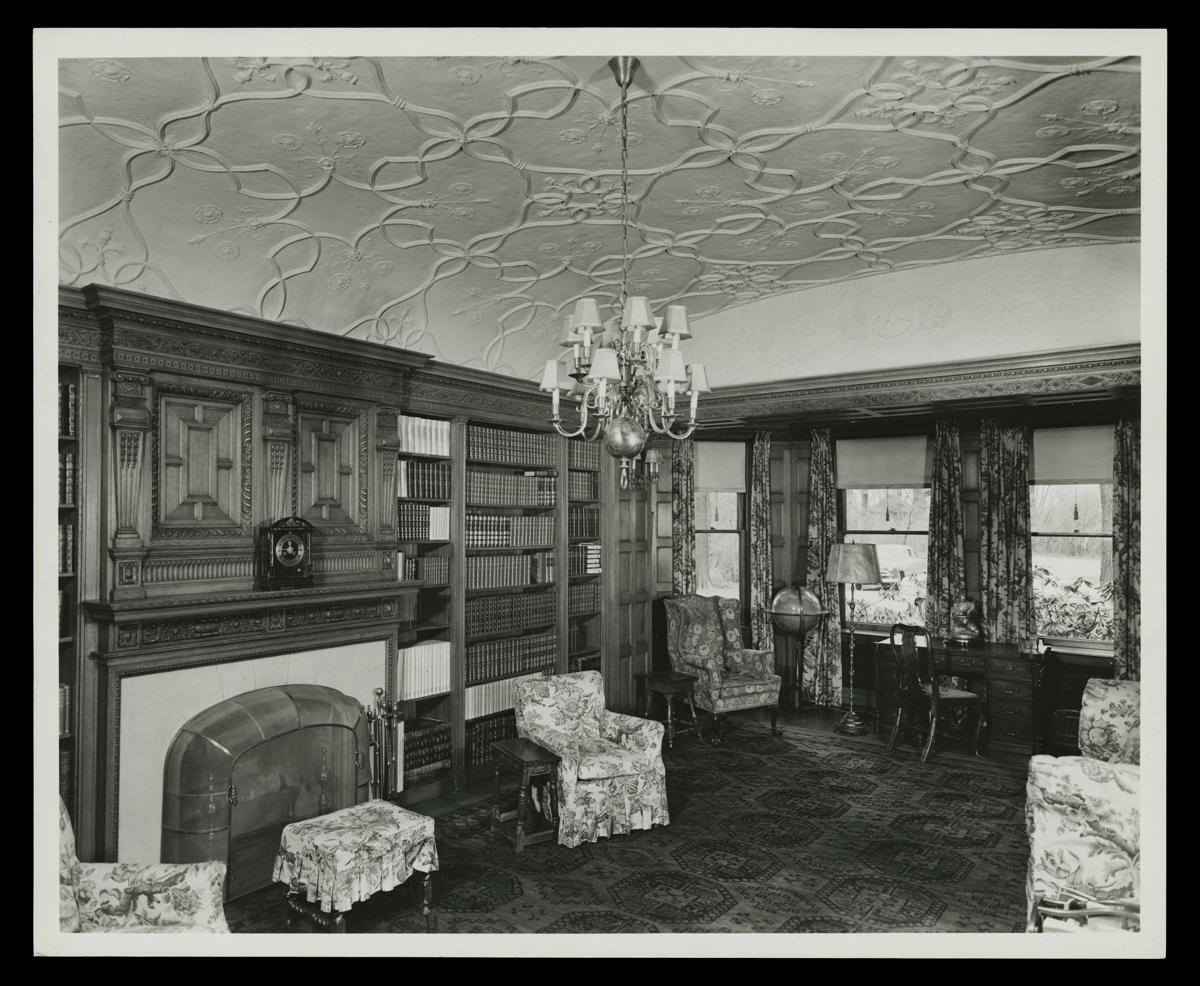 Interior of Fair Lane, Dearborn, Michigan, 1951 Room interior with carved wood, ornately patterned ceiling, bookcases, and upholstered chairs among other furniture