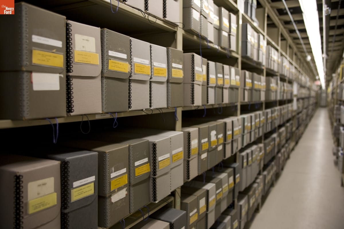 Shelves packed with gray boxes with yellow labels receding into the distance