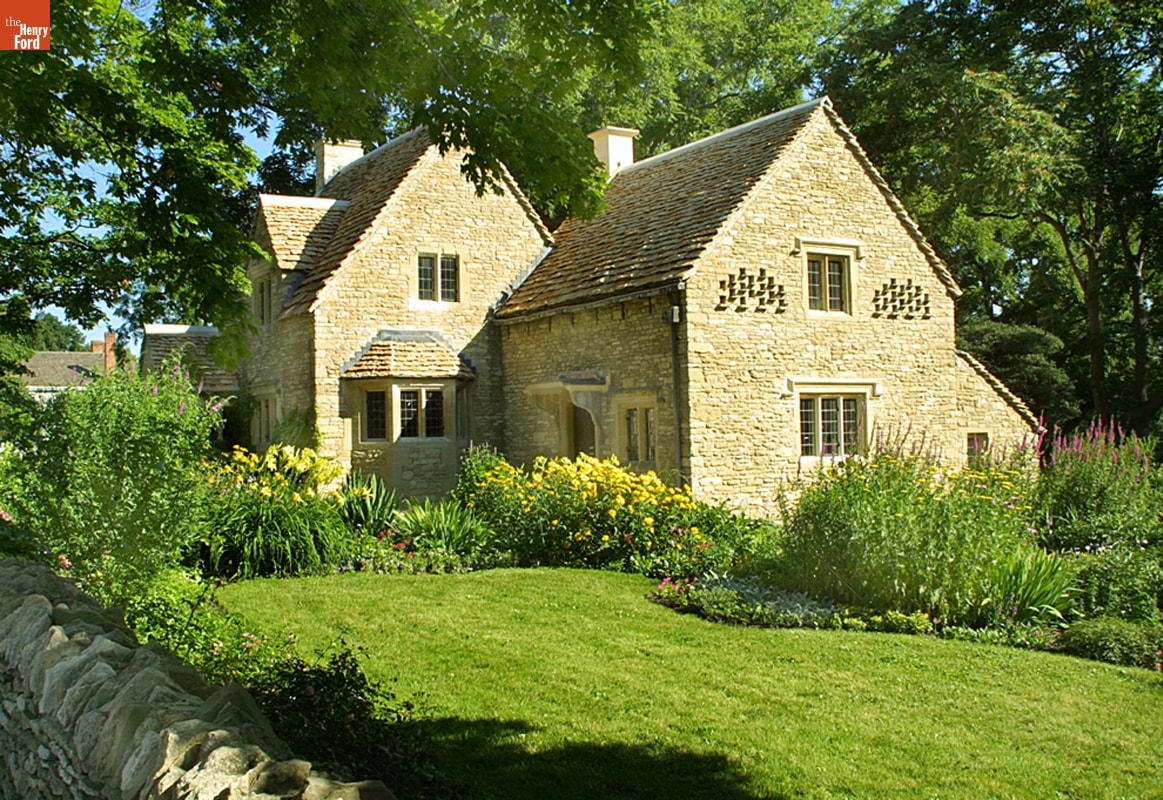 Cotswold Cottage Stone house with green lawn and lush flower garden