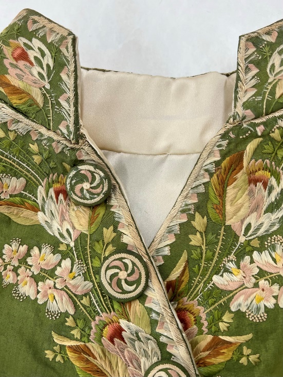 The finished collar and newly lined coat Detail of mandarin-style collar of moss-green jacket with detailed embroidery