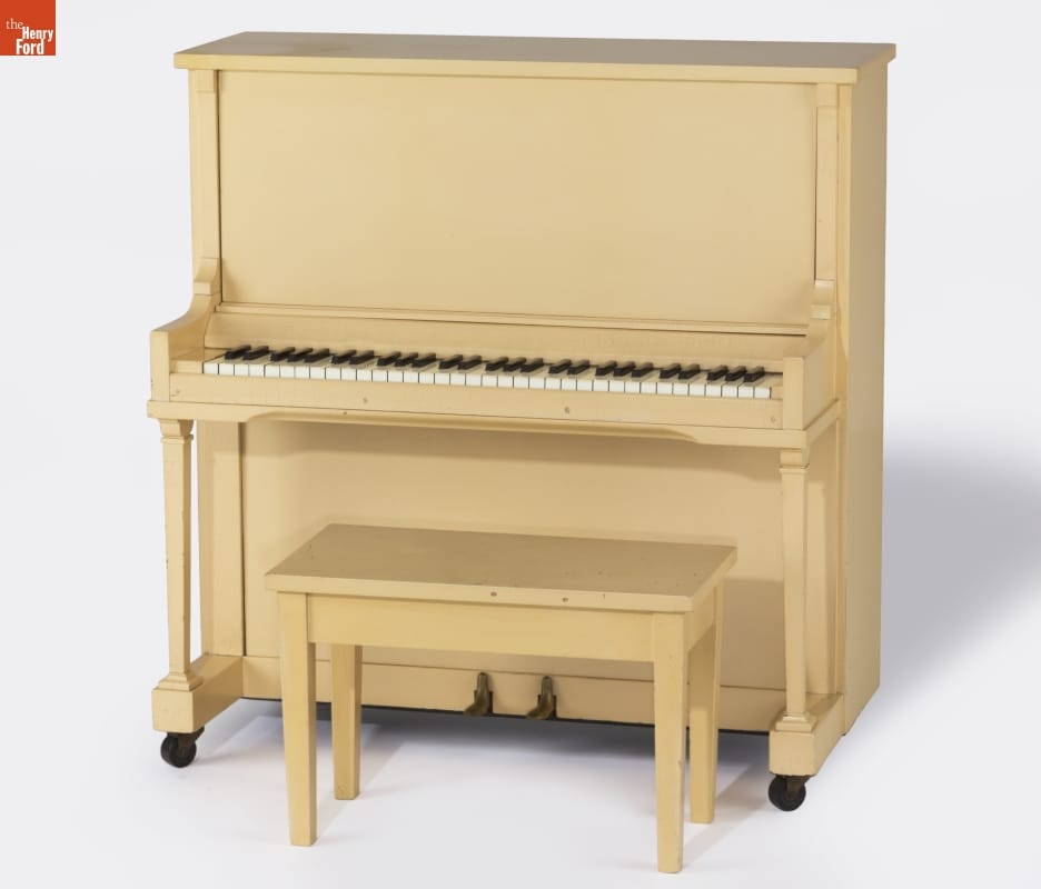Beige upright piano and piano bench