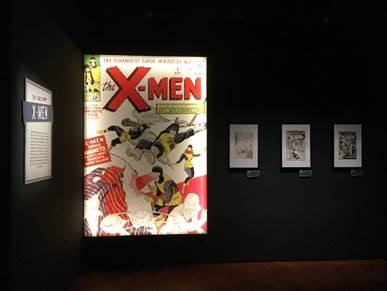 Oversized, illuminated comic book cover with images and text; framed text and images on walls on either side