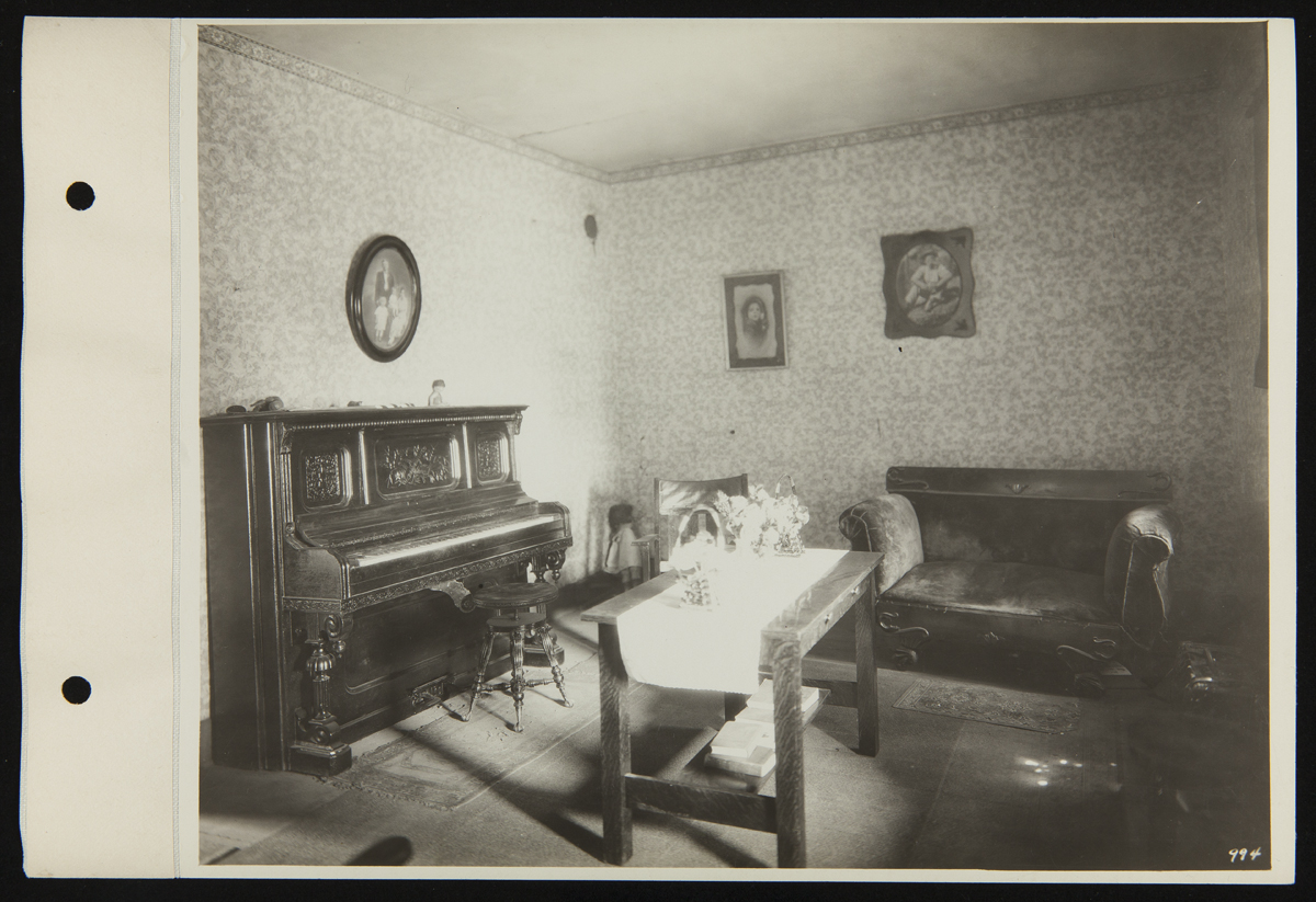 Room containing piano, table, sofa, among other items