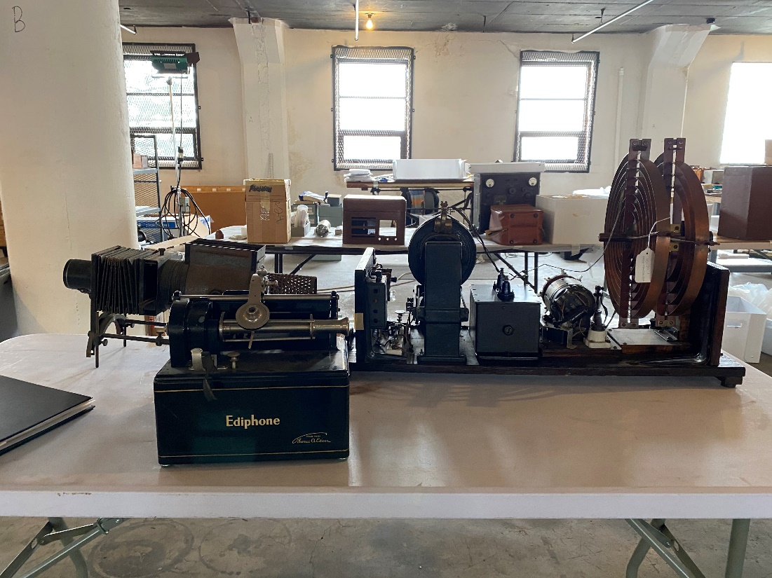 Communications and information technology collections gathered for inventory A variety of large equipment sits on tables in a large room