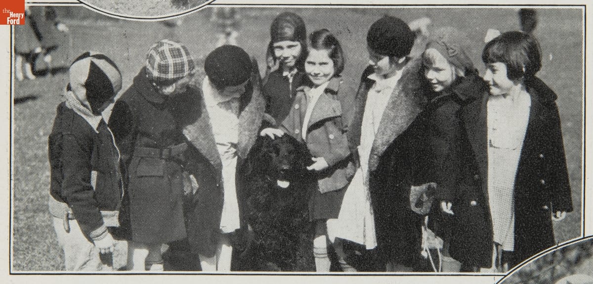 Herald, Vol. II, February 11, 1935-January 24, 1936 Group of children in coats gathered around seated large black dog