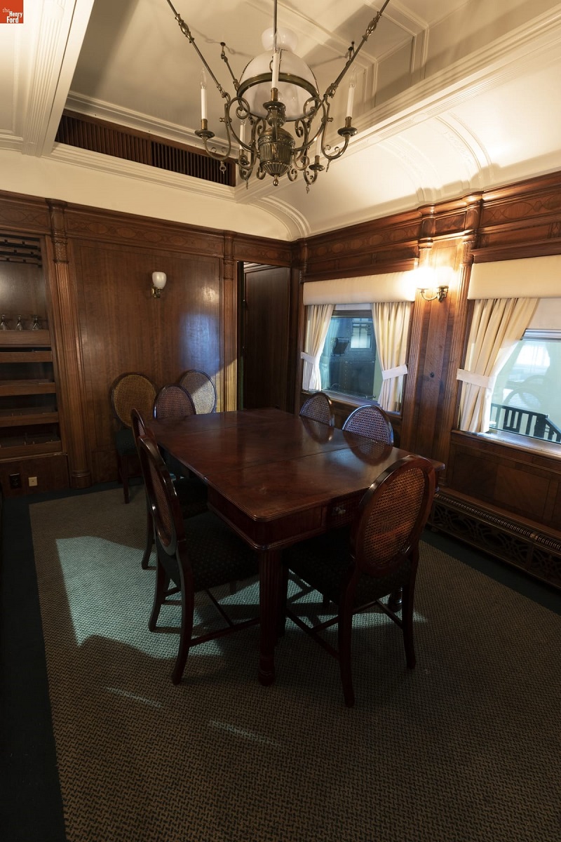 Henry Ford's Private Railroad Car "Fair Lane," 1921 / dining room Interior of room with wooden paneling and carpet, containing wooden dining table and chairs