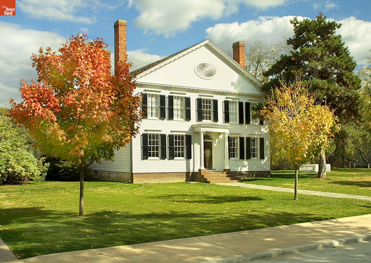 Noah Webster Home Two-story white wooden building with green lawn with a few small trees around it