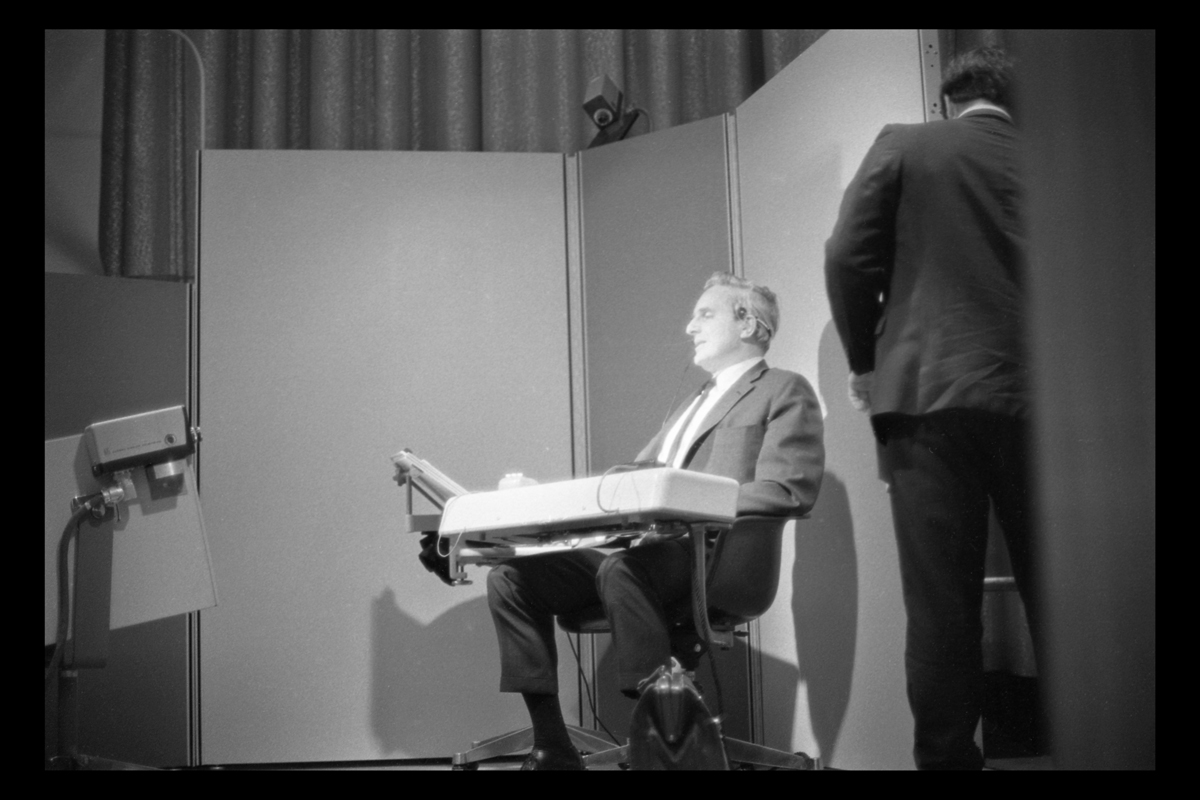 1968 Fall Joint Computer Conference, San Francisco, California, December 1968 Man sitting in chair with attached console, with video cameras pointed at him; another man to side