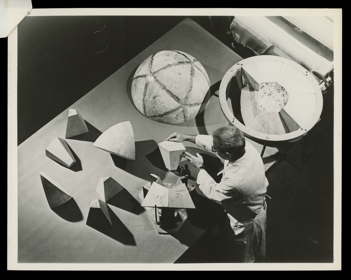 Lunar Capsule Balsa Wood Impact Limiter for NASA Ranger 3 Spacecraft, January 26, 1962 Photo from above of person in lab coat or apron working at table with hollow sphere in two pieces and various conic sections