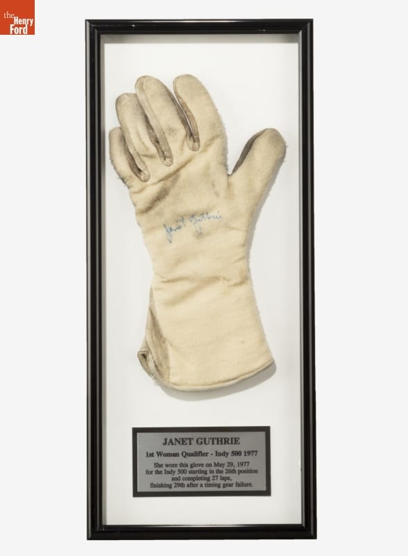 Racing Glove Worn by Janet Guthrie during the 1977 Indy 500 White glove in black frame with gold plaque containing text below it