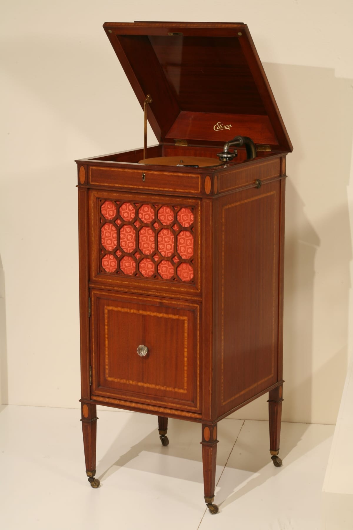 Edison Diamond Disc Phonograph, 1919 Wooden cabinet with four thin legs and decorative elements; top open to show machinery