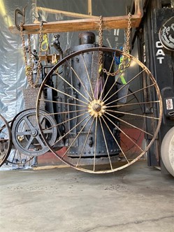 A Herschell-Spellman steam engine (27.139.1) rigged up for moving out of storage Machinery with large wheel suspended by heavy chains from a board or plank
