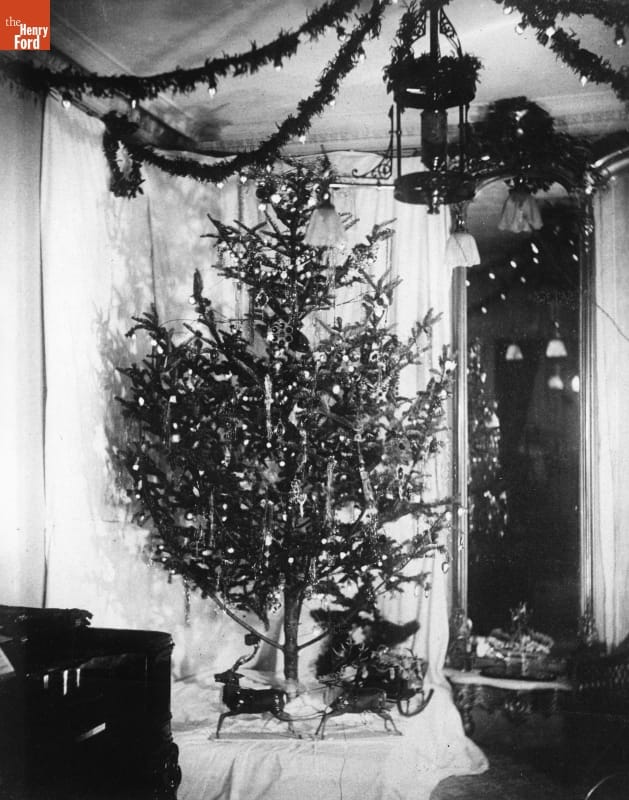 First Electrically Lighted Christmas Tree, Home of Edward H. Johnson, Vice-President of Edison Electric Light Company, December 1882 Black-and-white photo of Christmas tree in a room decorated with garland and other Christmas decorations