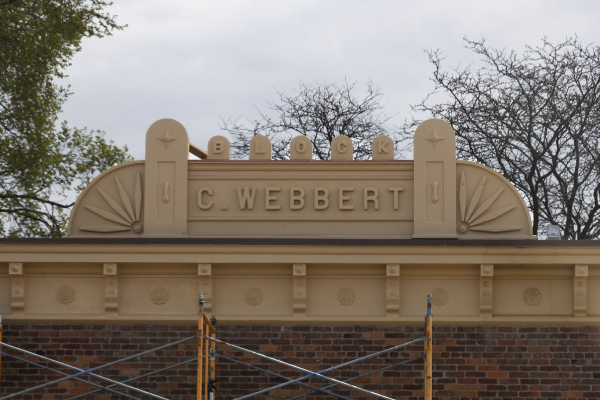 The C. Webbert Block sign atop Wright Cycle Shop in Greenfield Village Building roof with large sign with decorative elements and text reading "BLOCK C. Webbert"
