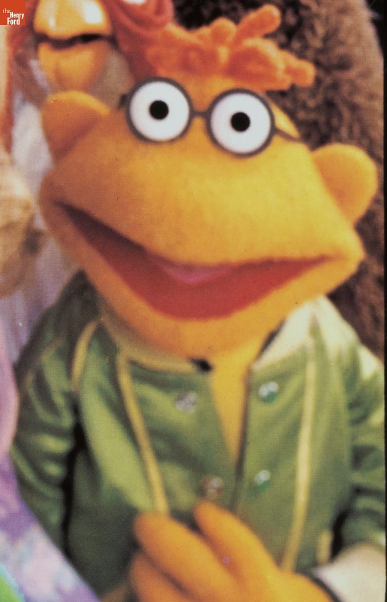"Jim Henson's Muppets" Lunchbox, 1979 / Scooter detail Yellow puppet with orange hair, glasses, and green satin jacket