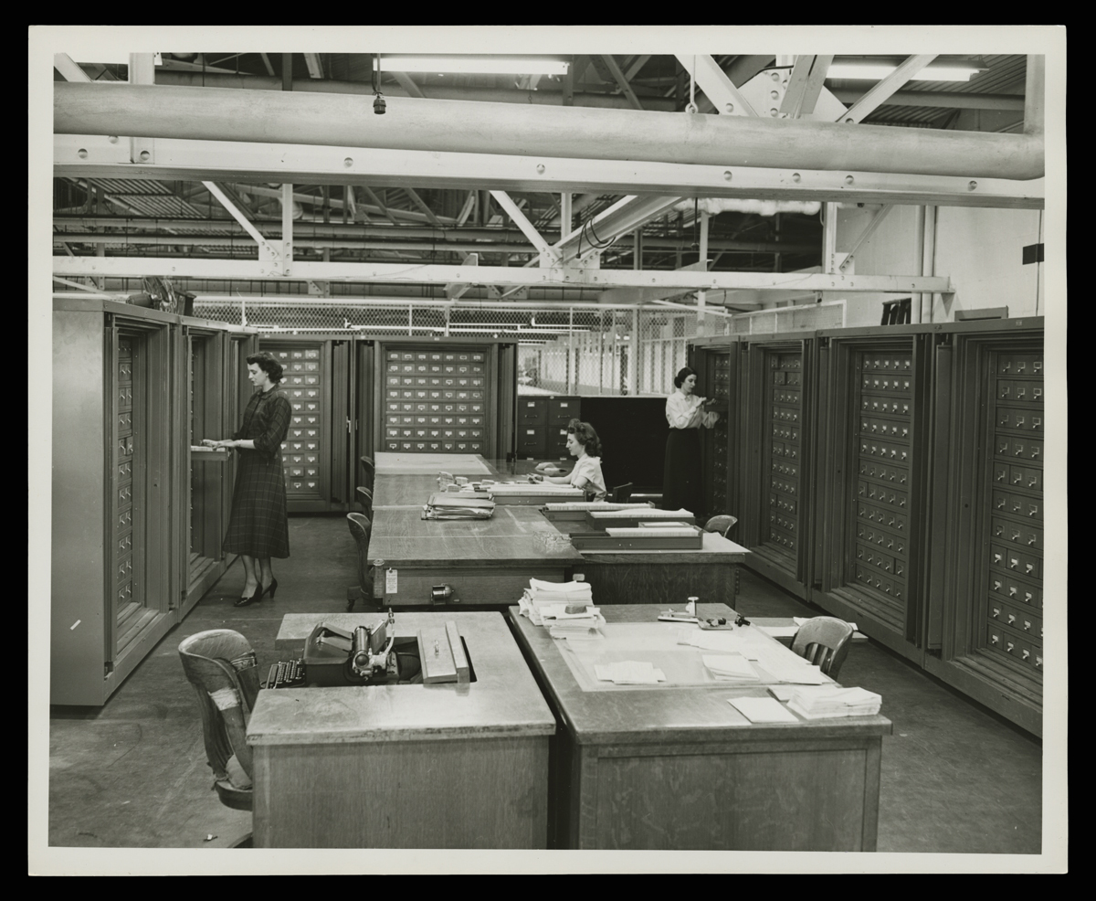 Office and Storage for Microfilmed Engineering Drawings at Ford Motor Company Rouge Plant, 1951 Three women in room with small filing cabinets along the walls and desks in the center