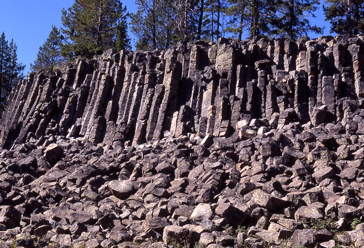 Angular, geometric rock cliff with loose rocks covering slope below