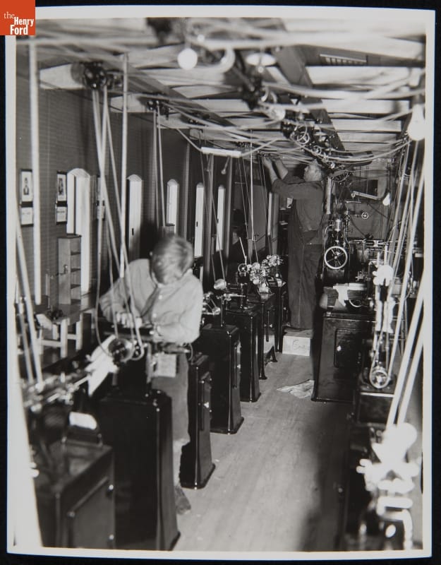 Boy stands at machine in room full of machines