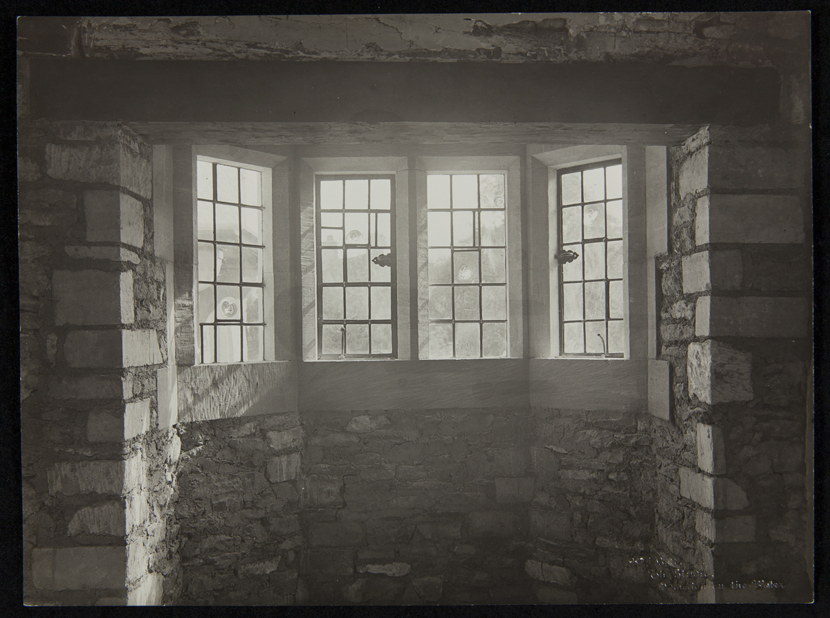 Interior view of bay window with four paned windows set in stone wall