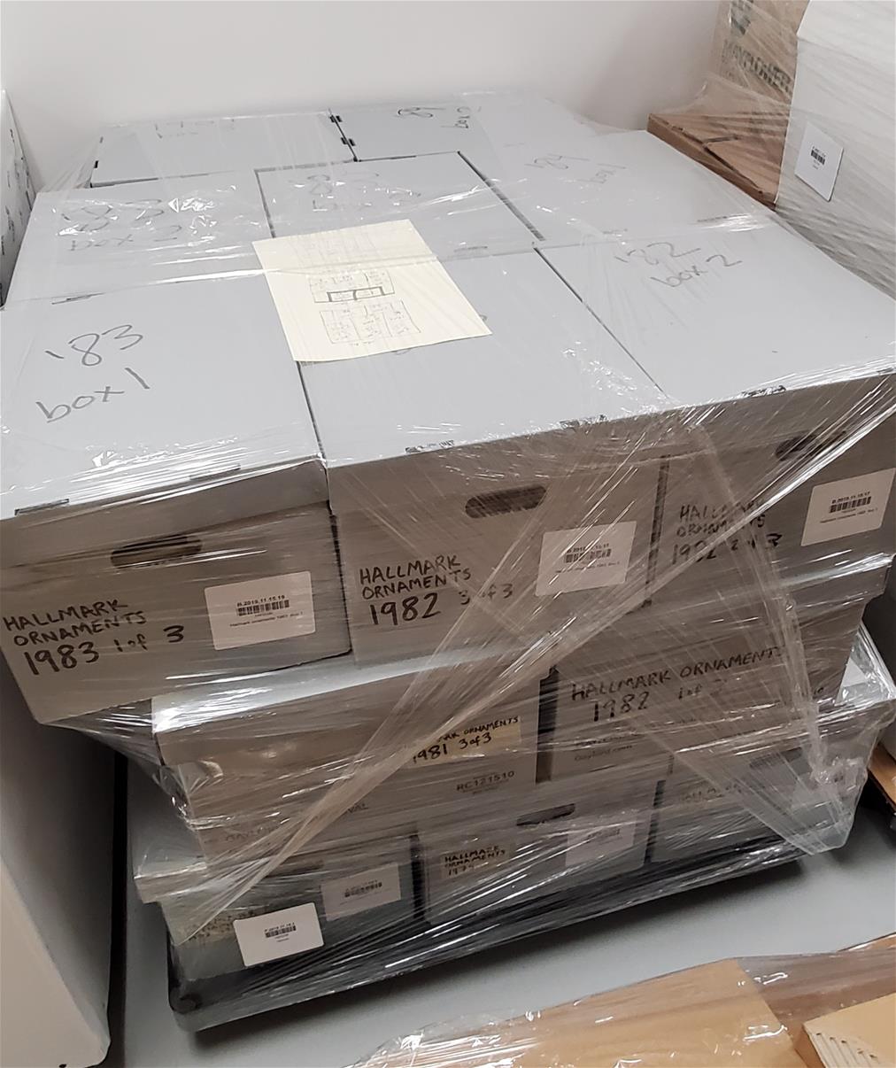 Palletized boxes shrink-wrapped to keep everything in place. Gray boxes stacked on pallet and secured with clear plastic wrap