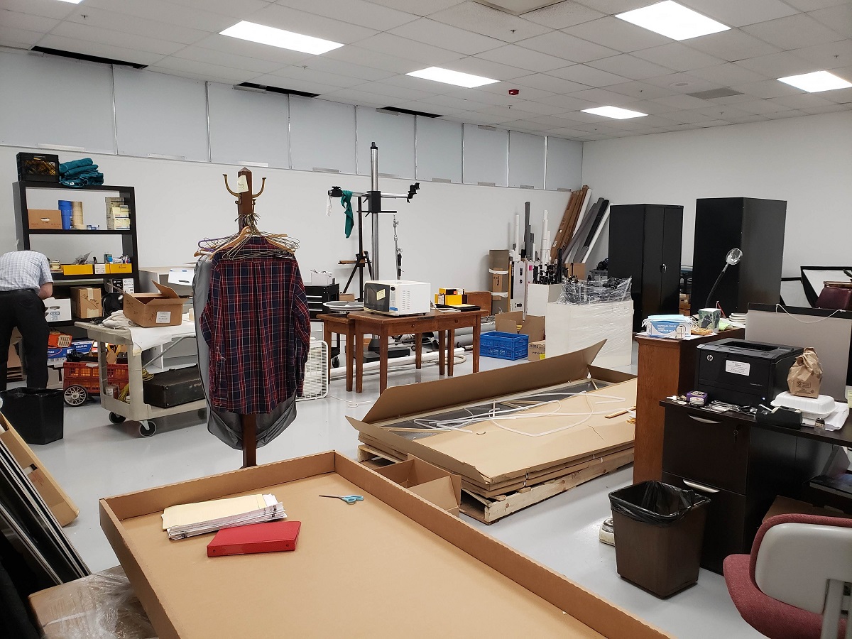 Room cluttered with large boxes, furnishings, and other items