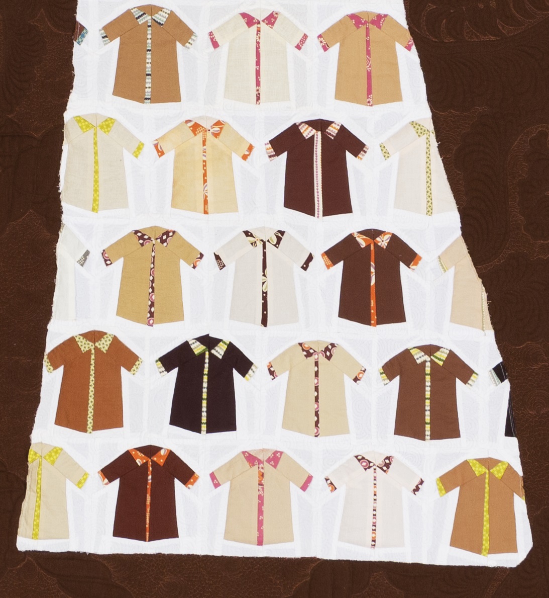 Fabric panel featuring a number of short-sleeved shirts on a white background with brown around the edge