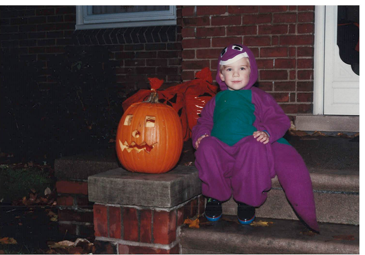THF710386 Eric Nietering proudly poses in the Barney costume made by his mother Emily.