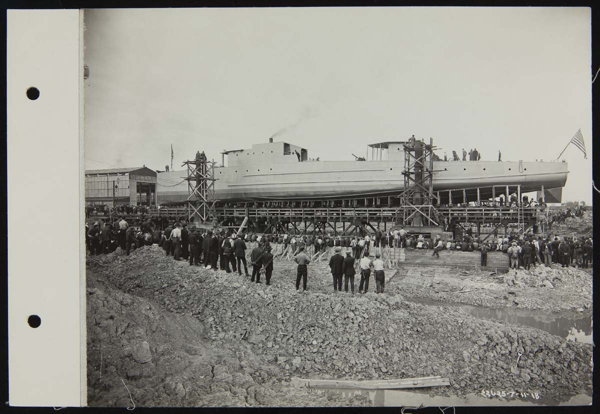 Eagle Boat #1 on Launching Trestle at the Ford Rouge Plant, July 11, 1918 Long, narrow boat on elevated trestle with a large group of people on land looking on